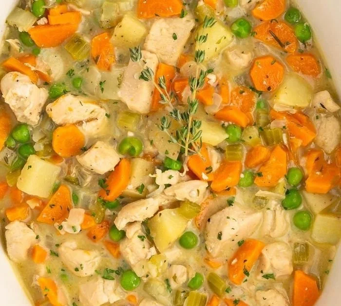 Bowl of hearty fall crockpot chicken stew filled with vegetables and spices