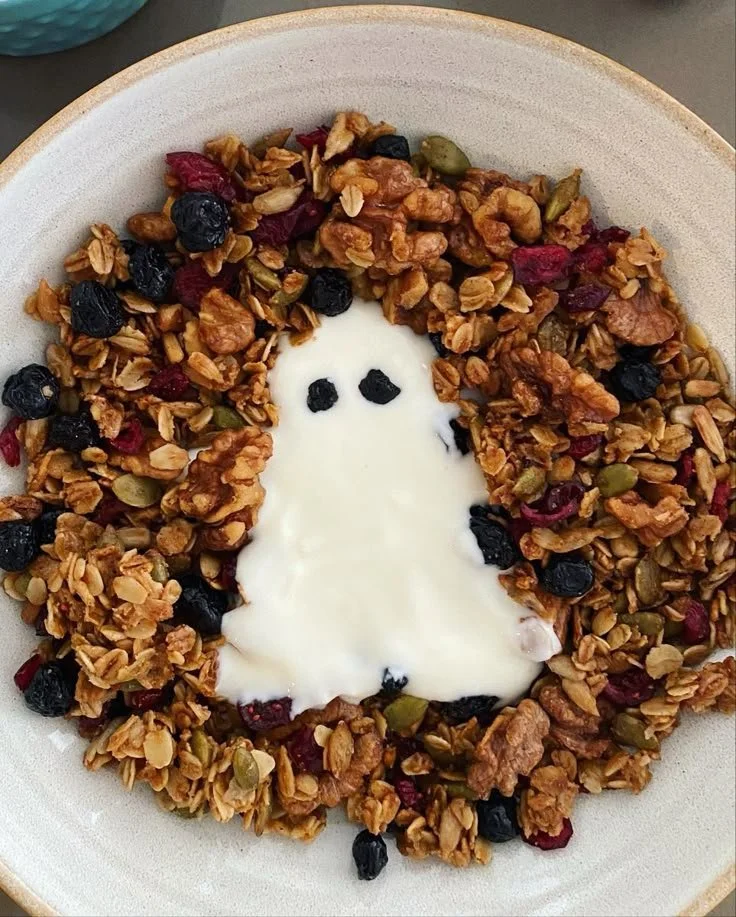 A bowl of ghost yogurt topped with fruits and granola, appealing and healthy